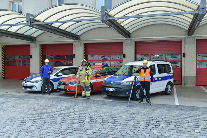 Auf diesem Bild sehen Sie den Werkschutz der InfraLeuna. Dazu gehören die Werksfeuerwehr und der Werkschutz selbst. In diesem Bild stehen 3 Personen, 1 Person pro Abteilung, vor ihren Fahrzeugen mit den jeweilligen Utensilien