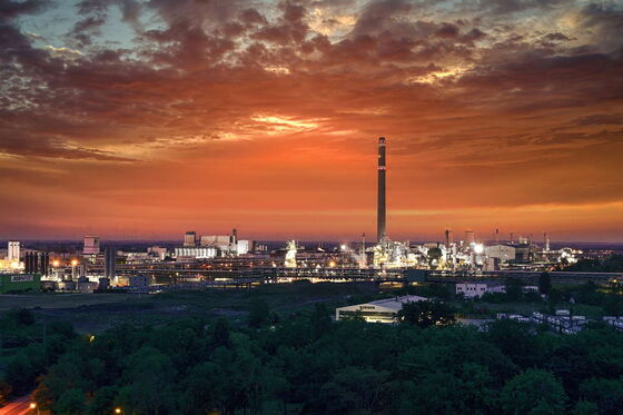 Auf diesem Bild sehen Sie den Chemiestandort, während im Hintergrund die Sonne untergeht und der Himmel langsam dunkler wird.